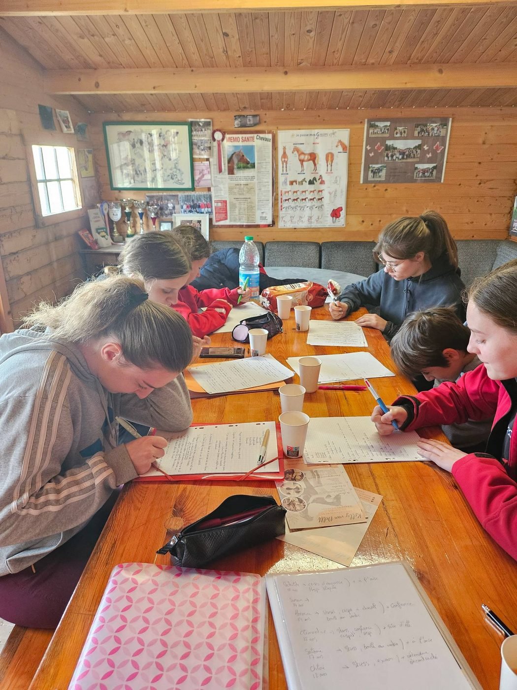 Jeunes cavaliers en atelier de préparation mentale, carnets ouverts, pendant un stage